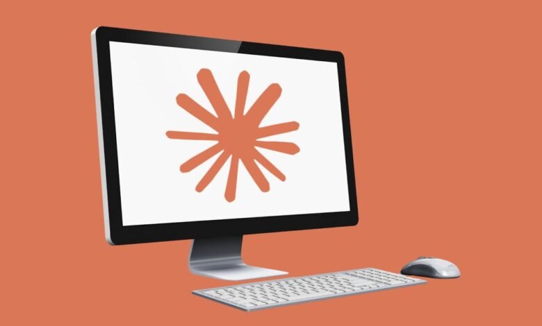 Computer with orange starburst on screen, keyboard and mouse.