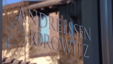 Andreesen Horowitz logo on glass door, building reflected.