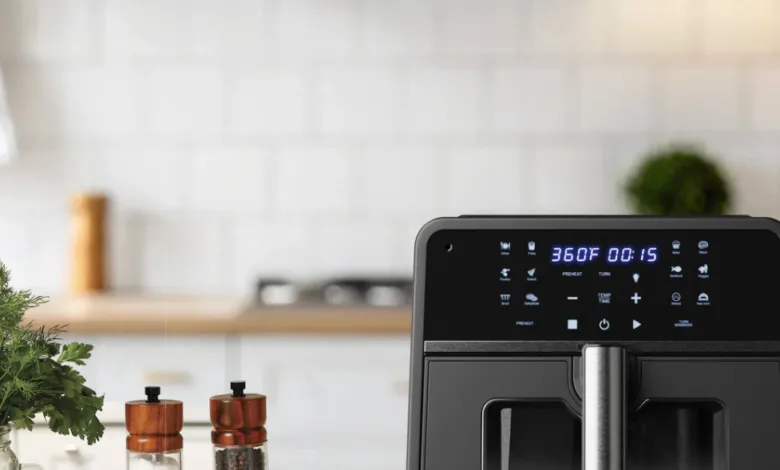 Black air fryer on kitchen counter displaying 360°F and 00:15 time.