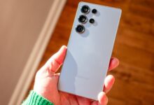 Hand holding a gray Samsung Galaxy S23 Ultra smartphone.