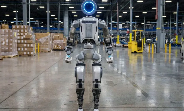 Boston Dynamics robot stands in a warehouse, facing forward.