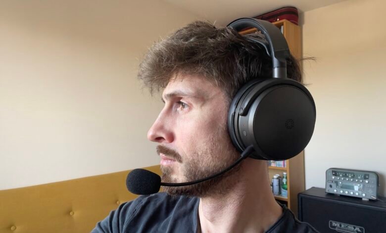 Man wearing black gaming headset with microphone, looking left.