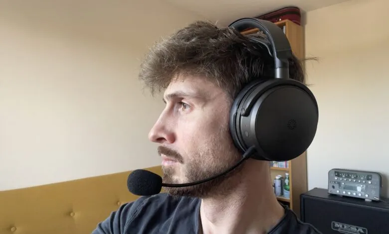 Man wearing black gaming headset with microphone, looking left.