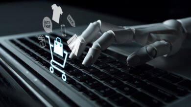 Robot hand types on laptop with shopping cart and sale icons.