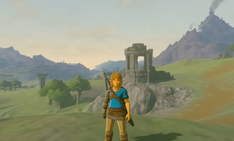 Link from Zelda stands in a field with mountains and ruins in the background.
