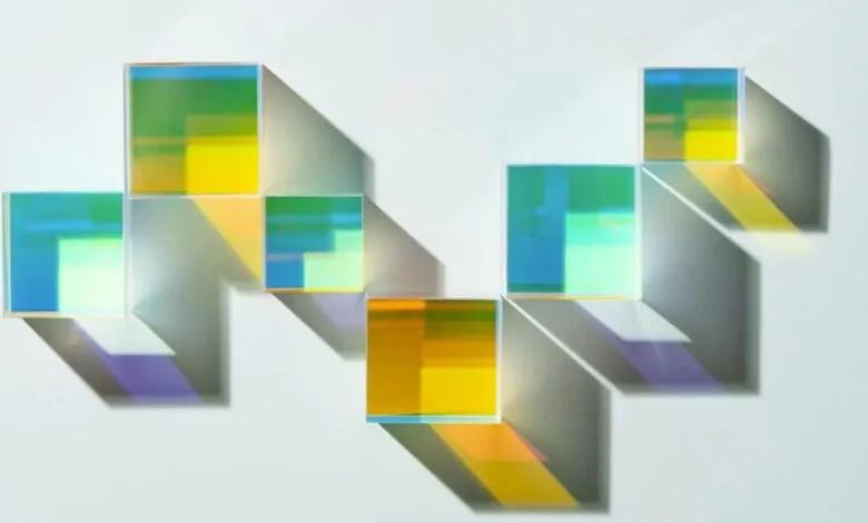 Arrangement of colorful translucent cubes casting shadows on white surface.
