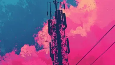 Silhouette of cell tower against a vibrant, colorful sky.