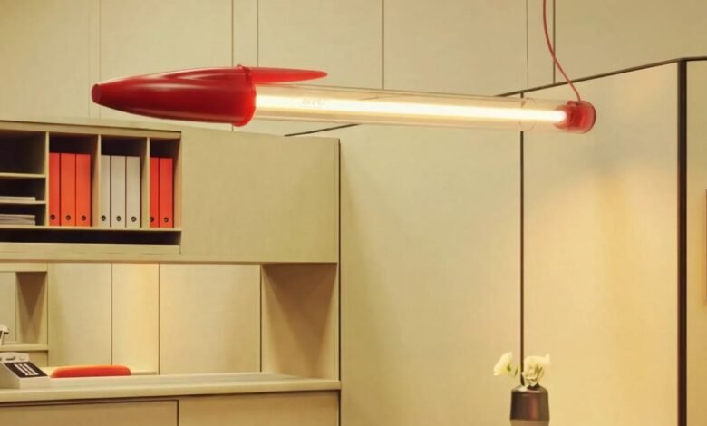 Novelty lamp shaped like a large Bic pen hanging in a modern office.