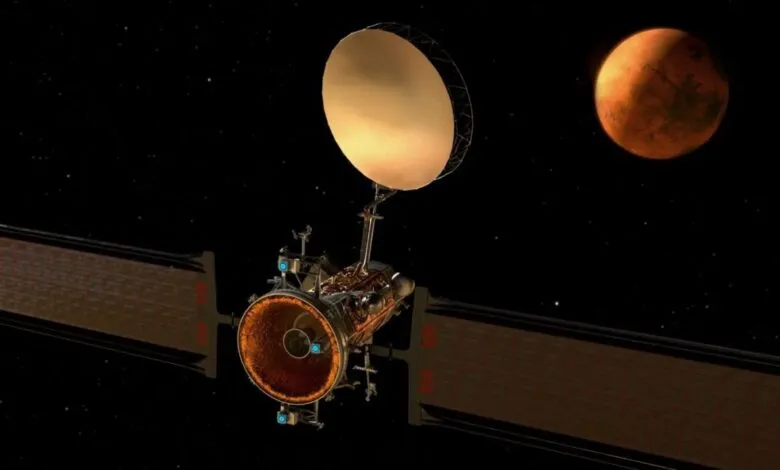 Spacecraft with large dish antenna orbiting Mars against a starry background.