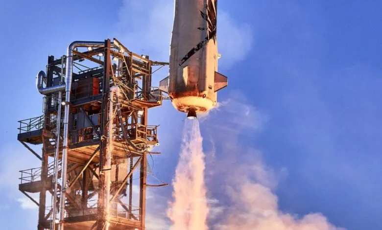 Rocket launching with exhaust plume against a blue sky.