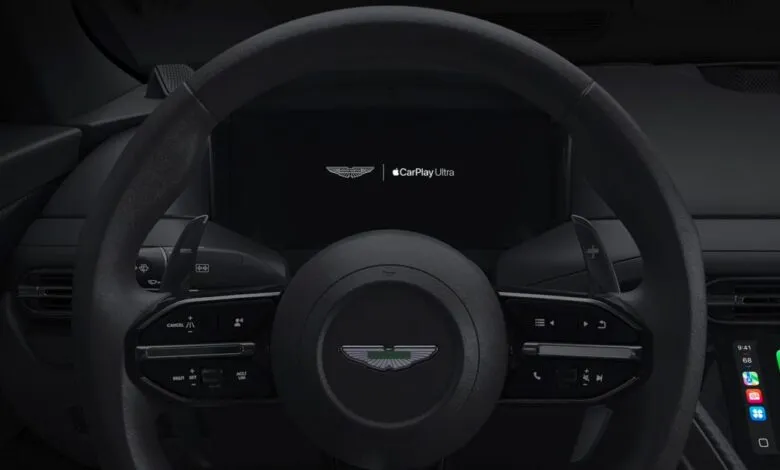 Aston Martin steering wheel with CarPlay Ultra display in a sleek, modern interior.