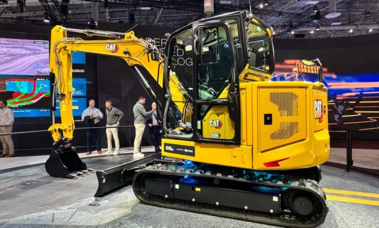 Yellow Caterpillar 306 excavator on display at a trade show.