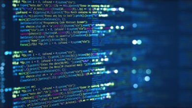 Lines of code displayed on a dark blue screen, bokeh lights in background.