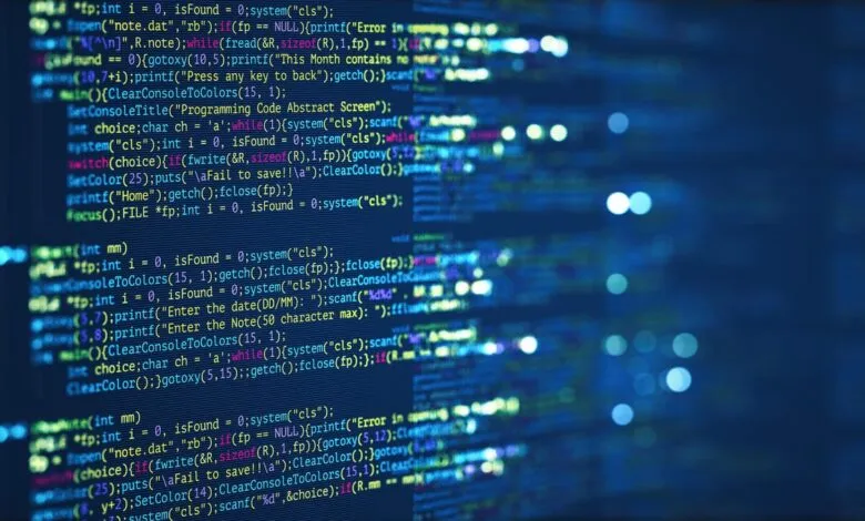 Lines of code displayed on a dark blue screen, bokeh lights in background.