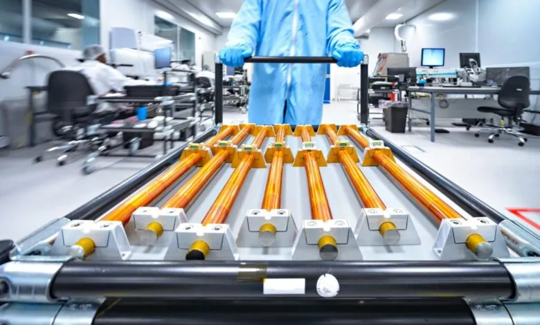 Copper rods on cart being moved in cleanroom environment.