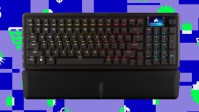 Corsair mechanical keyboard with RGB lighting and wrist rest on colorful background.