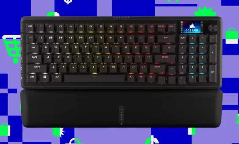 Corsair mechanical keyboard with RGB lighting and wrist rest on colorful background.