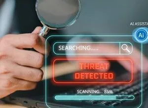 Threat detected on laptop screen, magnified by a hand holding a magnifying glass.
