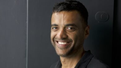 Portrait of Deepinder Goyal smiling against a dark gray background.