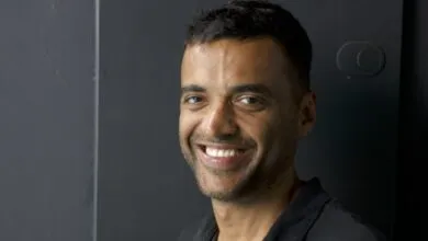 Portrait of Deepinder Goyal smiling against a dark gray background.