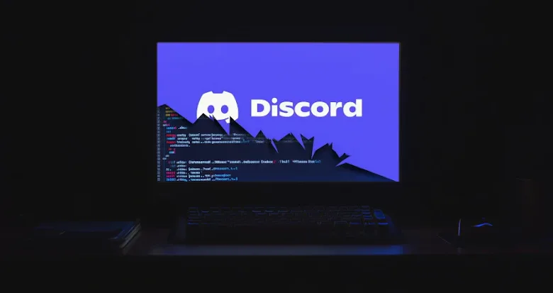 Computer screen displays Discord logo with code overlay, suggesting malware.