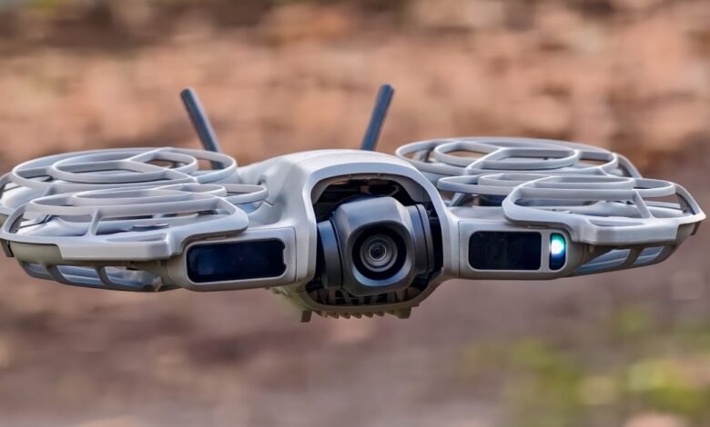 Close-up of a gray DJI drone in flight, camera facing forward.