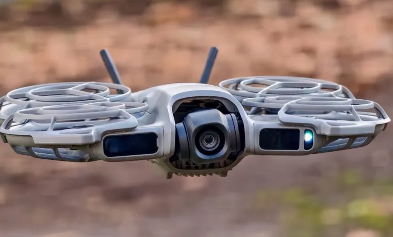 Close-up of a gray DJI drone in flight, camera facing forward.