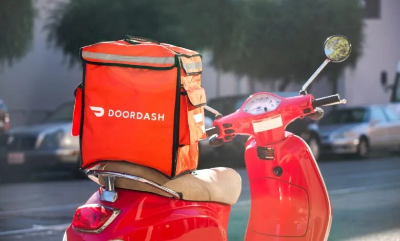 DoorDash delivery bag on a red scooter, ready for orders.