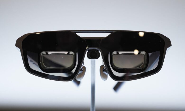 Close-up of black augmented reality glasses on a display stand.