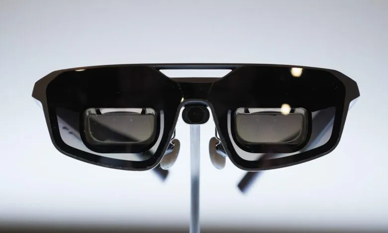 Close-up of black augmented reality glasses on a stand.