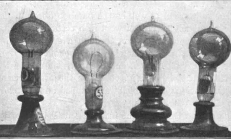 Four vintage light bulbs on display, each with a unique shape and base.