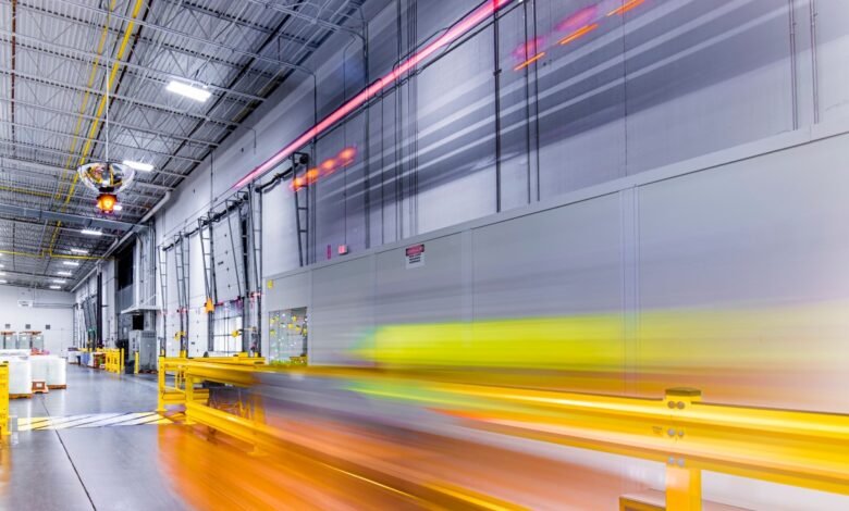 Interior view of a large warehouse with motion blur showing movement.