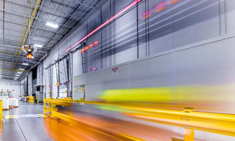 Interior view of a large warehouse with motion blur showing movement.