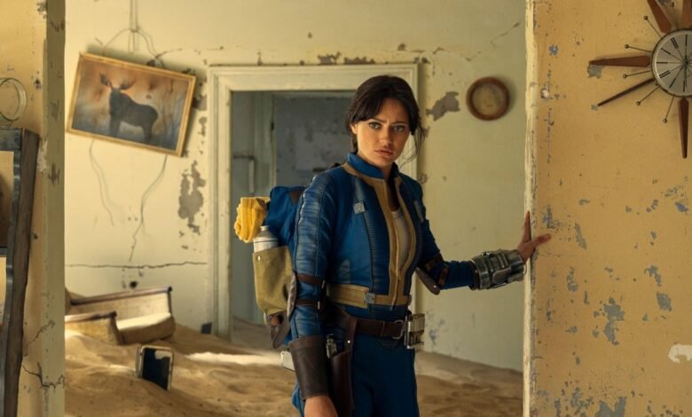 Ella Purnell as Lucy in Fallout, standing in a dilapidated room.