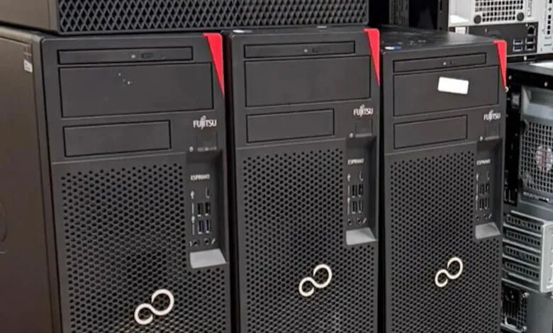 Three Fujitsu ESPRIMO computers lined up, black towers with red accents.