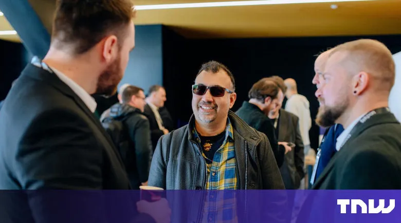 Attendees networking at a tech conference, smiling and engaged.