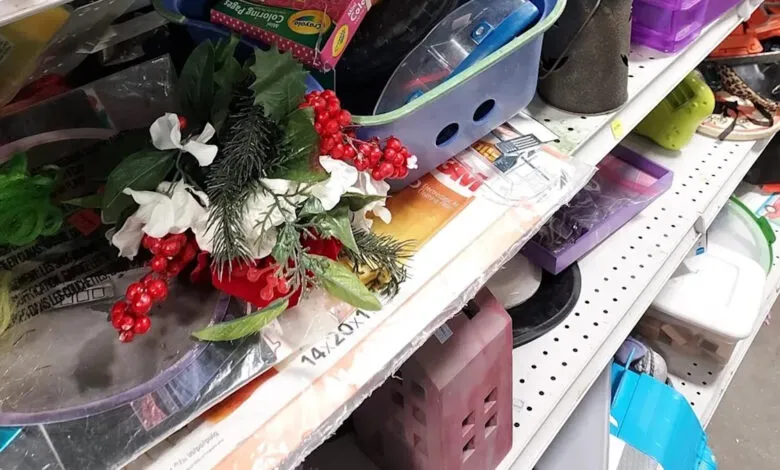 Overstuffed thrift store shelf with holiday decor and household items.