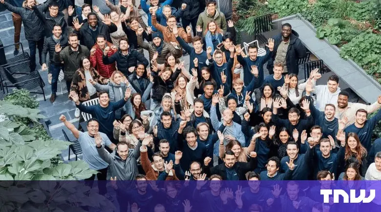 Large group of diverse people waving and smiling outdoors.
