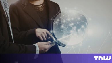 Two business professionals analyze data on a tablet with global network overlay.