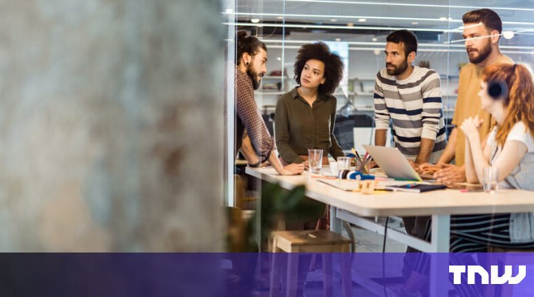 Diverse team collaborates around a table in a modern office space.
