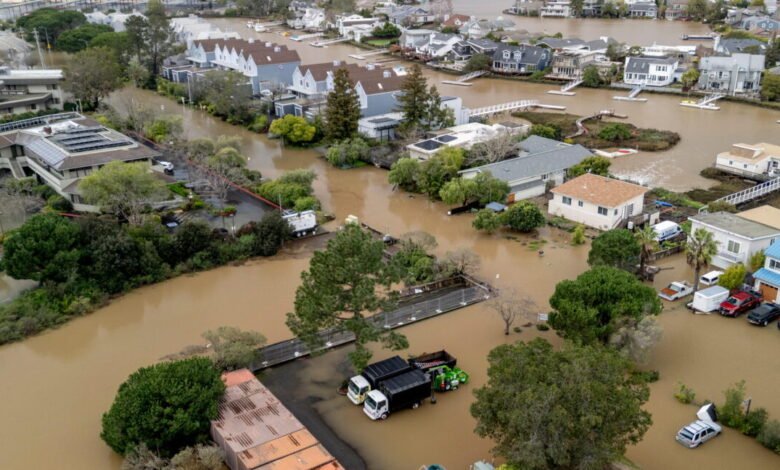 Aerial view of a flooded residential area with homes and vehicles submerged.