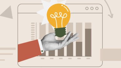 Hand holding lightbulb in front of bar graph on a screen.