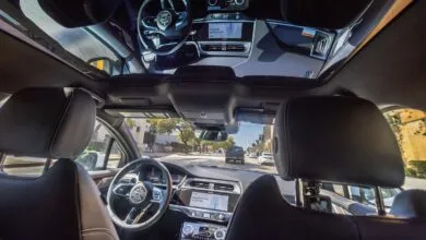 Interior view of car with sunroof, showing dashboard and road ahead.