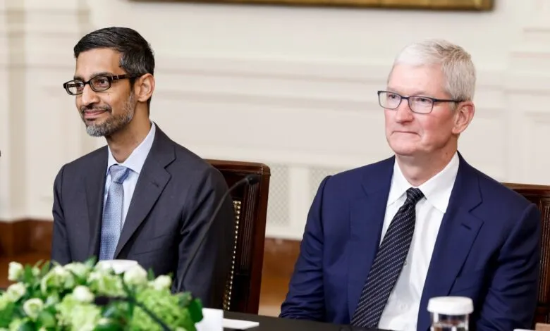 Sundar Pichai and Tim Cook seated at a table, looking forward.