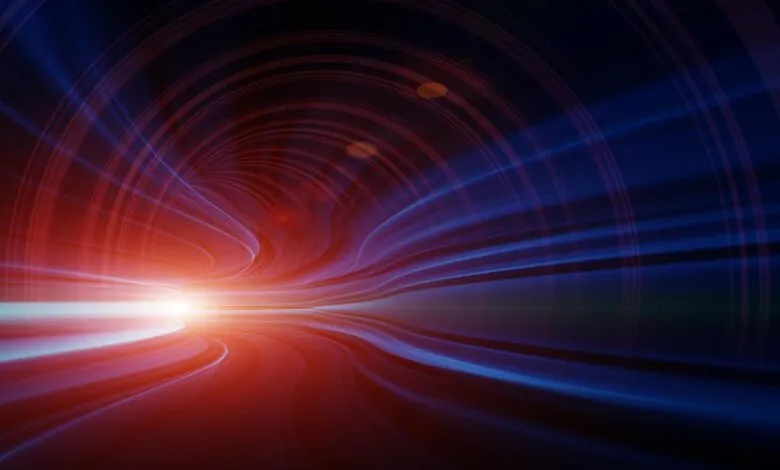 Abstract tunnel with red and blue light trails converging at a bright point.