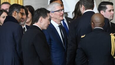 Group of people including Tim Cook and Sundar Pichai in suits.