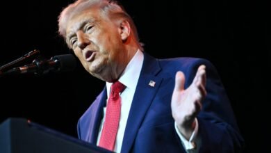 Donald Trump speaking at a podium with a microphone.