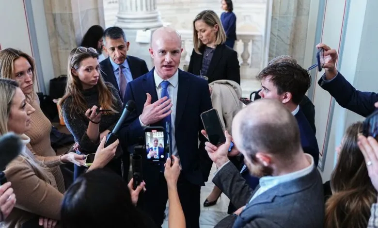 Mike Lee surrounded by reporters, speaking into microphones.