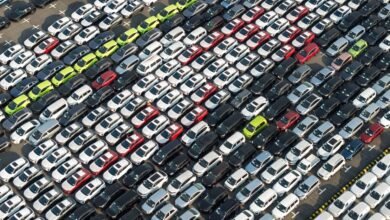 Aerial view shows rows of parked cars in various colors.