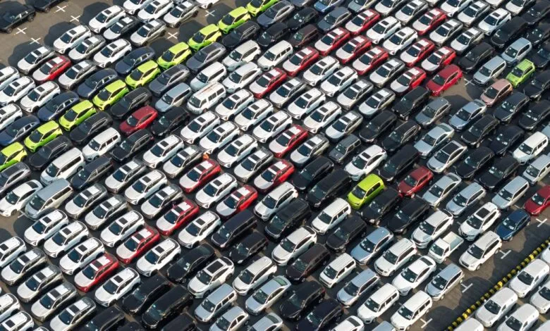 Aerial view shows rows of parked cars in various colors.